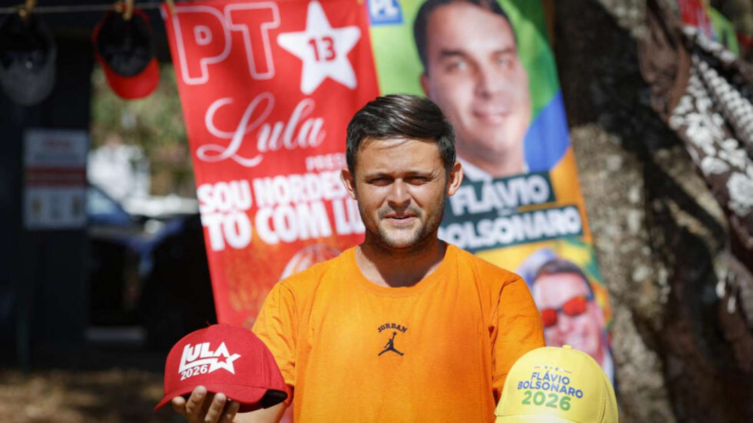 Um vendedor exibe bonés à venda dos candidatos à presidência do Brasil, Luiz Inácio Lula da Silva e Flávio Bolsonaro, em um bairro residencial de Brasília, em 11 de setembro de 2026.