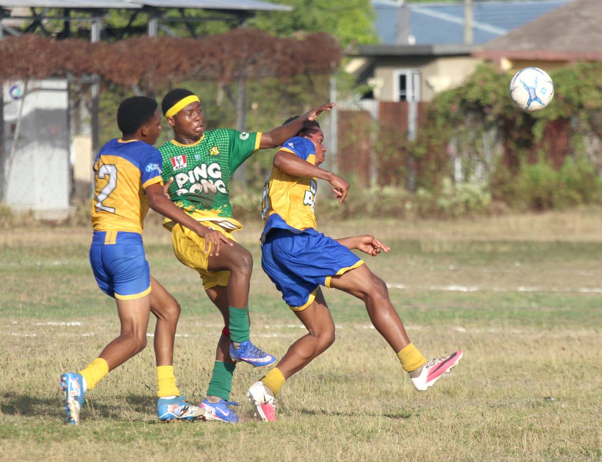 Rajay Smith (centre) challenges for the ball against two St Elizabeth Technical High School players during their Ben Francis Cup KO football match at the Linval Dixon Oval on Saturday.
