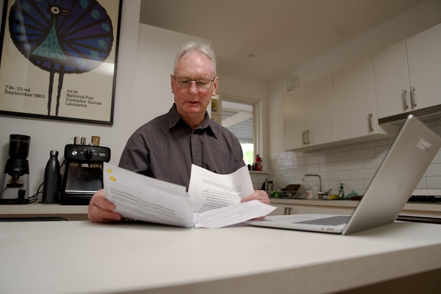Man looks at a letter from the Commonwealth Bank