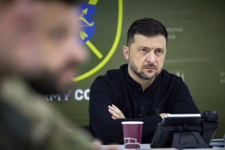 Volodymyr Zelenskyy listening with arms folded
