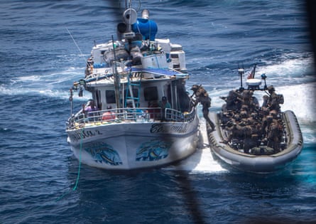 A person lifts leg onto one boat from a smaller boat