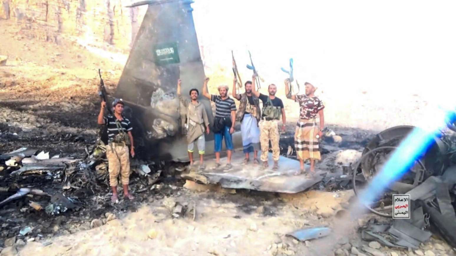 Combatentes houthis diante do que afirmam ser os destro&ccedil;os de um avi&atilde;o de combate saudita abatido, em local n&atilde;o especificado no I&ecirc;men, em imagem extra&iacute;da de um v&iacute;deo divulgado em 16 de setembro de 2026.